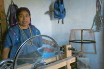 Matea spinning thread onto a spindle